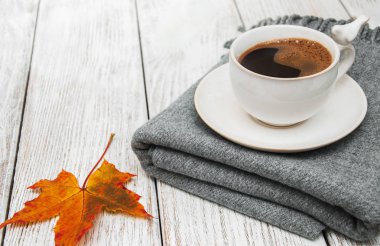 Bir fincan kahve ve sonbahar yaprakları.