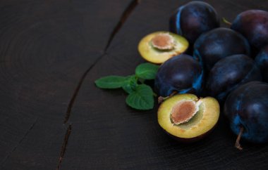 Fresh plums with green leaves