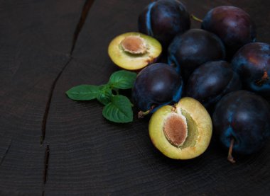 Fresh plums with green leaves