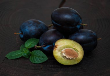 Fresh plums with green leaves