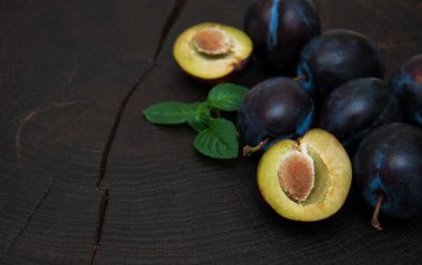 Fresh plums with green leaves