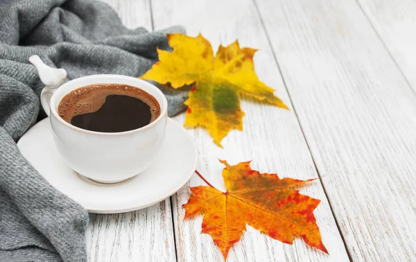 Bir fincan kahve ve sonbahar yaprakları.