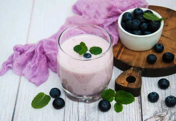 Brýle s borůvkový jogurt na stůl — Stock fotografie