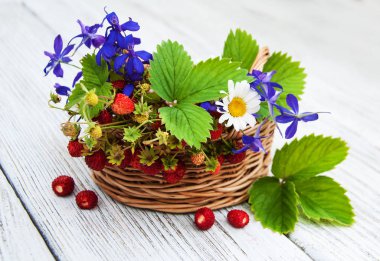 Yaban çilekleri ve kır çiçekleri sepeti