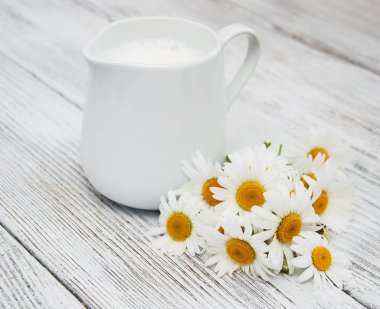 süt ve papatya çiçeği ile sürahi