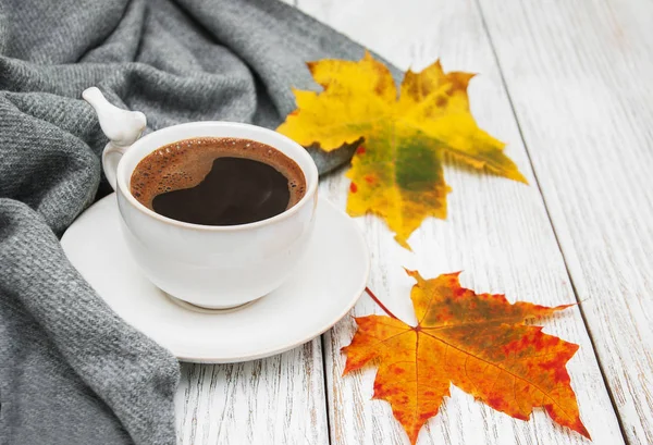 Bir fincan kahve ve sonbahar yaprakları.