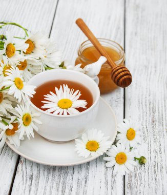 Papatya çiçekli bir fincan bitki çayı.