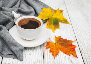 Bir fincan kahve ve sonbahar yaprakları.
