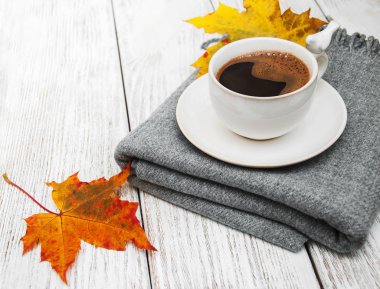 Bir fincan kahve ve sonbahar yaprakları.