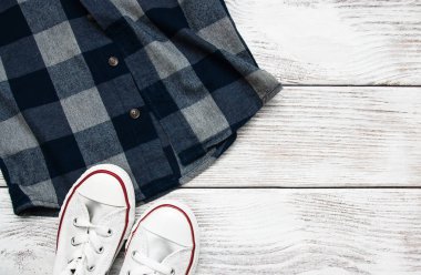 Beyaz spor ayakkabı ile damalı gömlek