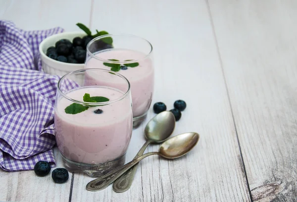 Vasos con yogur de arándano sobre una mesa —  Fotos de Stock