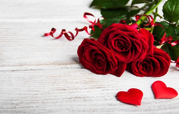 Rode rozen op een tafel — Stockfoto