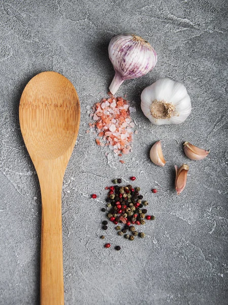 Skje av tre med hvitløk, salt og pepper – stockfoto