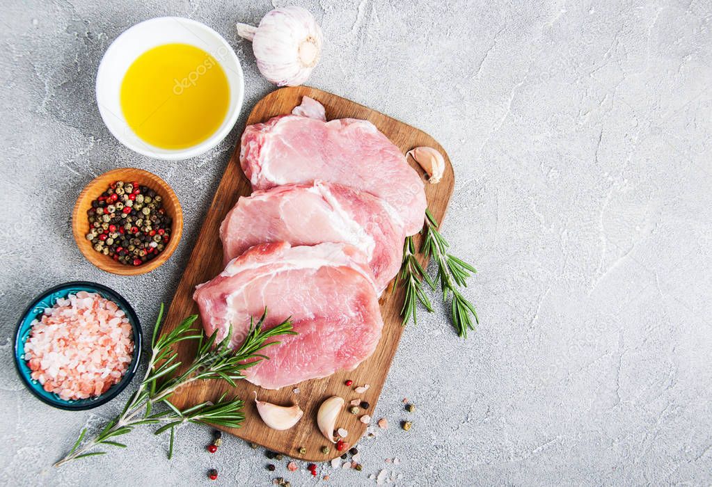 Fresh raw pork chops with spices and herbs