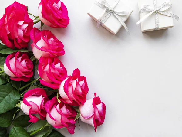 Rosas vermelhas e caixas de presente em um fundo branco — Fotografia de Stock