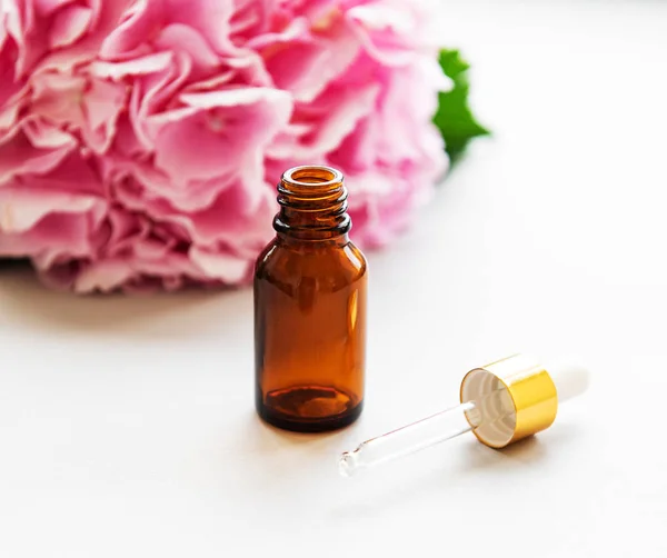 Pink hydrangea and massage oil — Stock Photo, Image