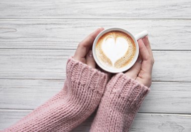 Bir fincan kahve tutan kadın.