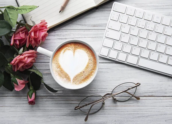 En kopp kaffe med hjertemønster på et bord. – stockfoto