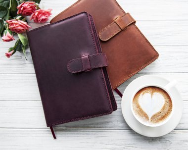 Deri defterler ve bir fincan kahve.