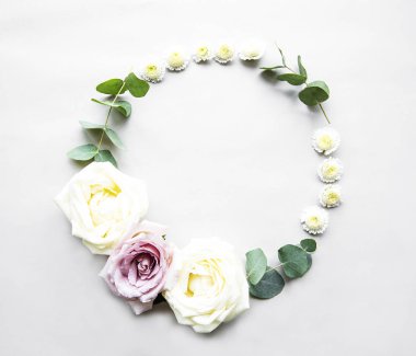 Pembe ve beyaz güller ve beyaz arka planda yapraklarla dekoratif daire çerçevesi. Düz yatıyordu