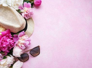 Pembe bir beton arka planda pembe şakayık ve şapka