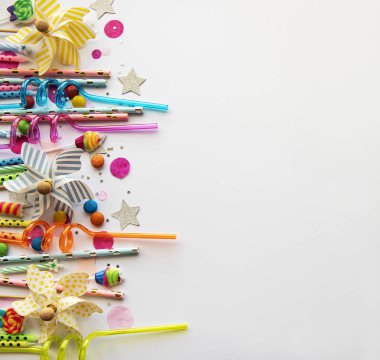 Mutlu yıllar ya da parti geçmişi. Doğum günü pipetleri, konfetiler ve beyaz arka planda şekerler. Üst Manzara. Boşluğu kopyala.