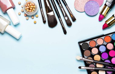 Açık mavi bir arka planda dekoratif kozmetik seti. Düz yatış, üst görünüm.