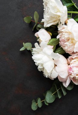 Siyah beton arka planda pembe şakayıklar olan bir arka plan