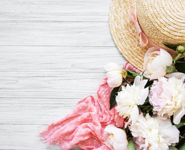 Tatil yaz arka plan. Pembe şakayık ve şapka beyaz ahşap arka plan üzerinde.