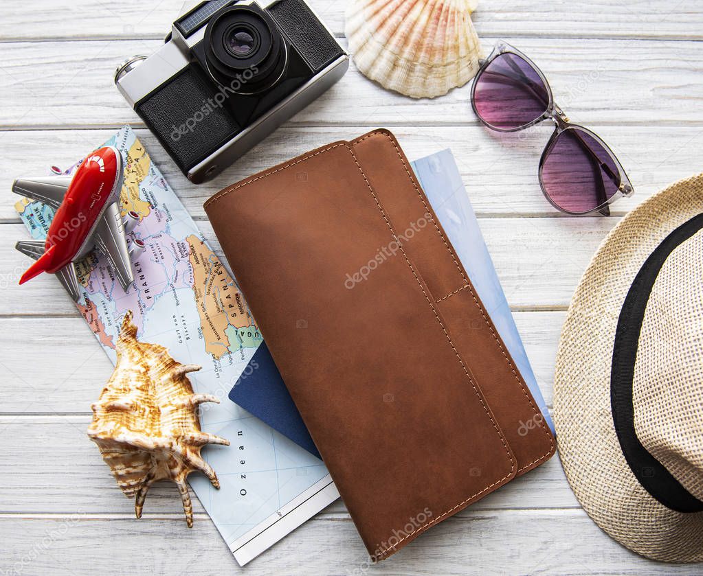 Brown leather travel organizer on white wooden table.  Flat lay, top view. Travel concept.