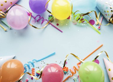 Mutlu yıllar ya da parti geçmişi. Doğum günü balonları, konfeti ve kurdeleler mavi arka planda. Üst Manzara. Boşluğu kopyala.