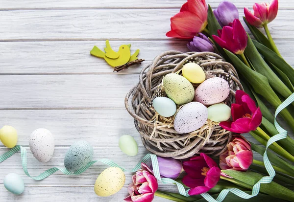 Pasen Achtergrond Met Kleurrijke Eieren Nest Roze Tulpen Een Witte — Stockfoto