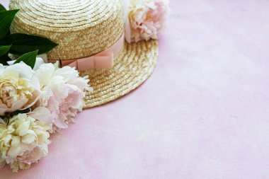 Tatil yaz geçmişi. Beyaz ahşap arka planda pembe peonies, güneş gözlüğü ve şapka.