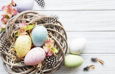 Beyaz ahşap arka planda renkli yumurtaları olan Paskalya arkaplanı. Kopyalama alanı olan üst görünüm