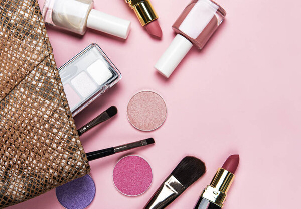 Set of decorative cosmetics on a pastel pink background. Flat lay, top view.