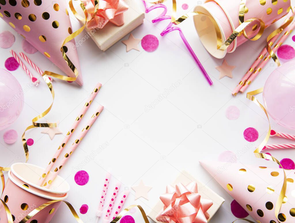 Happy birthday or party background.  Flat Lay wtih birthday hats, confetti and ribbons on white background. Top View.  Copy space.