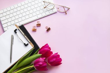 Üst kattaki ofis masasında yatıyordu. Çalışma alanı boş klavye, klavye, ofis malzemeleri, masa üzerinde kalem, lale.