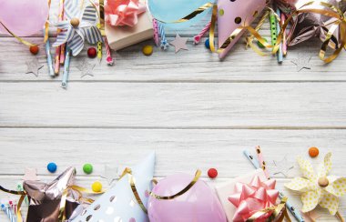 Mutlu yıllar ya da parti geçmişi. Doğum günü şapkaları, konfeti ve beyaz ahşap arka planda kurdeleler. Üst Manzara. Boşluğu kopyala.