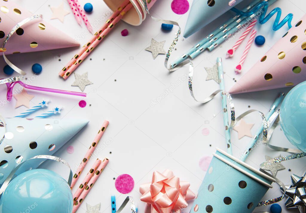 Happy birthday or party background.  Flat Lay wtih birthday hats, confetti and ribbons on white background. Top View.  Copy space.