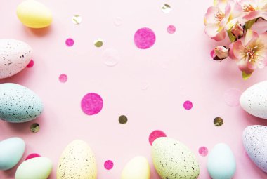 Pastel pembe arka planda renkli Paskalya yumurtaları. Paskalya tatili konsepti, düz konum, üst manzara.