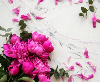 Düz kompozisyon ve pembe şakayık çiçekleri mermer bir sırtüstü yatıyordu.