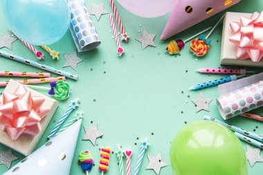 Mutlu yıllar ya da parti geçmişi. Doğum günü balonları, konfeti ve pastel yeşil arka planda kurdeleler. Üst Manzara. Boşluğu kopyala.
