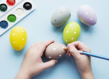 Mutlu Paskalyalar. Paskalya yumurtası boyayan küçük bir kız çocuğu. Paskalya için hazırlanıyorum. Paskalya yumurtası taşıyan bir kızın elleri. yakın plan