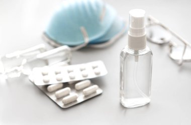 Solunum maskeleri ve antiseptik sprey beyaz arka planda