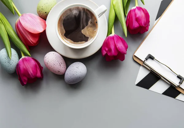Šálek Kávy Šedém Pozadí Bílé Tulipány Velikonoční Vajíčka Prázdný Klipbiard — Stock fotografie