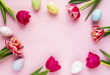 Pembe pastel arka planda bahar laleleri ve Paskalya yumurtaları