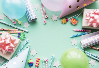 Mutlu yıllar ya da parti geçmişi. Doğum günü balonları, konfeti ve pastel yeşil arka planda kurdeleler. Üst Manzara. Boşluğu kopyala.