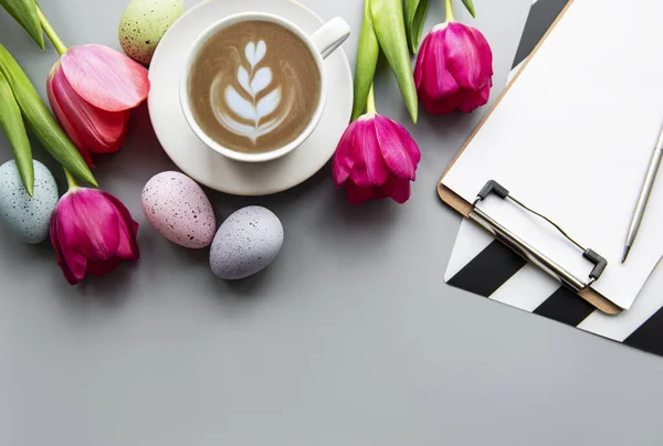Šálek Kávy Šedém Pozadí Bílé Tulipány Velikonoční Vajíčka Prázdný Klipbiard — Stock fotografie