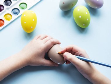 Mutlu Paskalyalar. Paskalya yumurtası boyayan küçük bir kız çocuğu. Paskalya için hazırlanıyorum. Paskalya yumurtası taşıyan bir kızın elleri. yakın plan