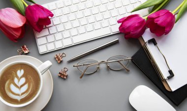Üst kattaki ofis masasında yatıyordu. Çalışma alanı boş klavye, klavye, ofis malzemeleri, masa üzerinde kalem, lale.
